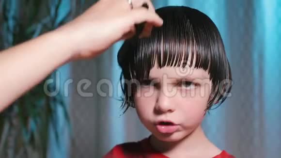 在男孩头上剪头发的特写视频的预览图