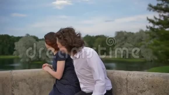 两个相爱的年轻人在石凳上拥抱视频的预览图