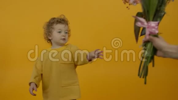 可爱的卷发孩子拿着黄色背景的花束视频的预览图