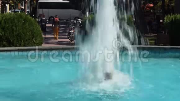 喷泉溅起蓝色的水花一对人在公园里远走高飞视频的预览图