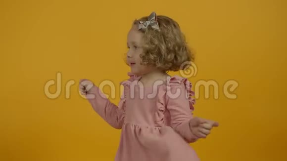可爱的卷发孩子穿着黄色的衣服四处张望视频的预览图