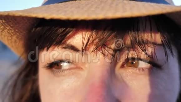 女人关注某人日落时戴帽子的女人特写视频的预览图