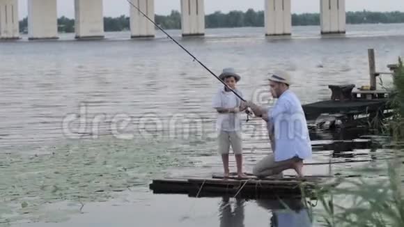 幸福的家庭关系有爱心的父亲和他的孩子在户外钓鱼时一起在码头上玩视频的预览图