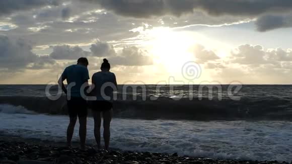 太阳落山时站在黑海海岸上的一家人视频的预览图