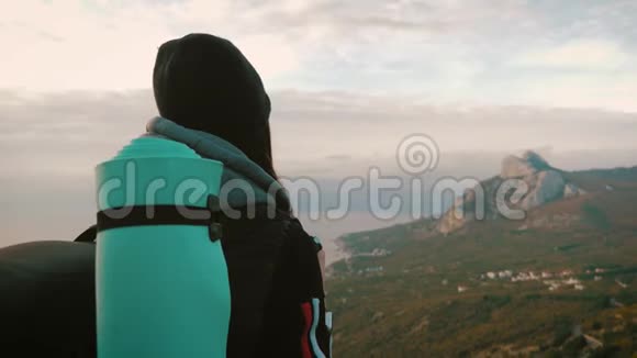 日落时带背包的女旅行者在山上徒步旅行剪影徒步旅行自由和幸福的概念视频的预览图
