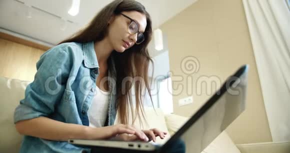 年轻女士在笔记本电脑上打字视频的预览图