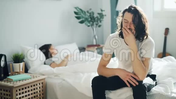 伤心的男人坐在床上与妻子争吵后摸着脸女孩睡觉视频的预览图