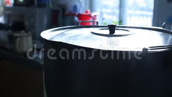 在厨房的炉子上放着一个白色蒸汽的大型古董平底锅视频的预览图