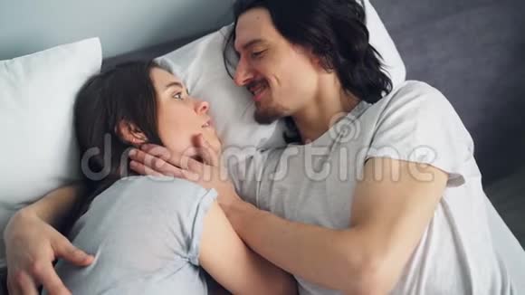 从高角度看幸福夫妇在床上拥抱接吻视频的预览图
