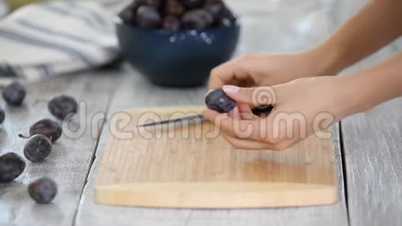 厨师用刀切熟李子在木切割板上在户外做饭健康的水果视频的预览图