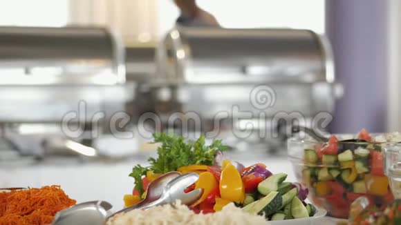 一个带盘子的女人把食物放在自助餐上在酒店餐厅自助服务在盘子里装满各种食物视频的预览图