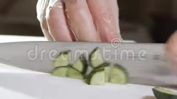 男厨师慢动作切鲜菜在厨房餐厅用刀切黄瓜特写厨师手视频的预览图