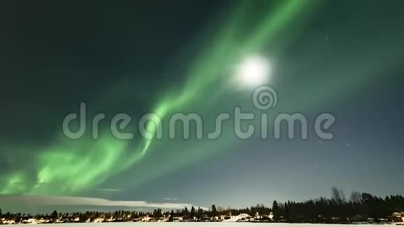 在瑞典冰冻的湖泊和冬季景观上闪耀着灿烂的绿色极光的视频来自满月和北方的光线视频的预览图
