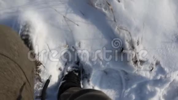 冬天一个穿黑鞋的人走在白雪上视频的预览图