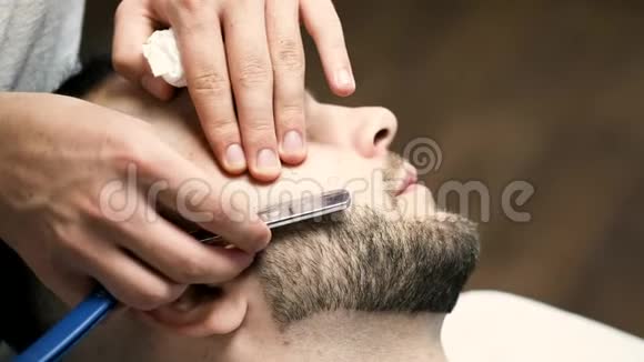 理发店理发师剪客人胡须过程的特写视频的预览图