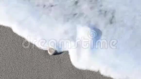 夏天海滩上的海浪和泡沫洗涤的卵石视频的预览图