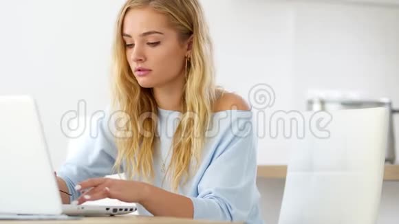 有魅力的年轻学生女孩正在家里学习使用笔记本电脑打字和阅读反馈信息教育和生活方式概念视频的预览图