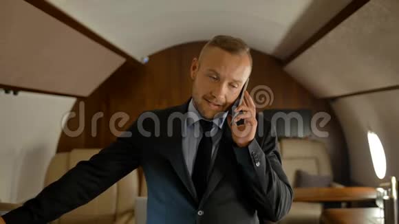 私人飞机商务旅程概念商人用手机说话视频的预览图