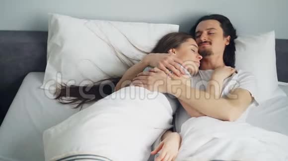 男人和女人的一对夫妇躺在床上拥抱享受着睡觉的乐趣视频的预览图