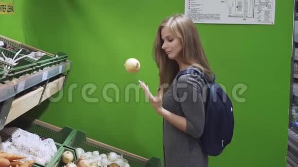 可爱的小女孩在超市选择蔬菜穿灰色连衣裙的快乐女孩在购物时摆弄蔬菜视频的预览图