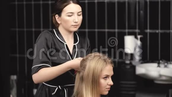 理发师穿黑色制服为沙龙客户做发型视频的预览图