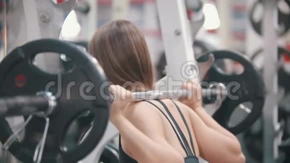 一位在健身房训练的女运动员放下哑铃擦去额头上的汗视频的预览图