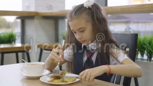 学生小学穿着校服坐在学校食堂的一张桌子东西视频的预览图