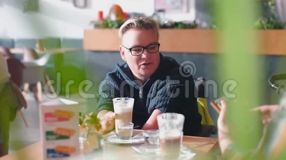 一个女人和一个对话者坐在餐馆的桌子旁视频的预览图