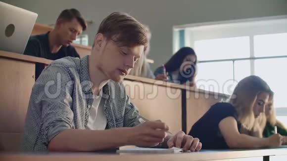 大学或学院的学生用笔记本电脑写讲座在研究所毕业视频的预览图