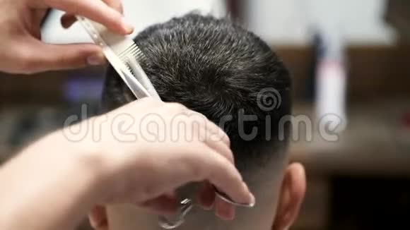 理发师在理发店用剪刀剪人的头发视频的预览图
