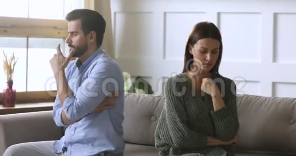 不幸的倔强的年轻夫妇分开坐着回到沙发上视频的预览图