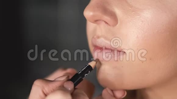 化妆师用铅笔画嘴唇的特写视频的预览图