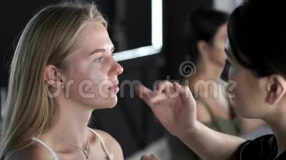 化妆师穿着黑色制服和美容店的客户视频的预览图