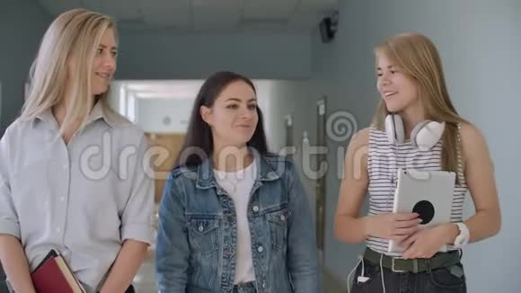 三个年轻女孩走在大厅里交流视频的预览图
