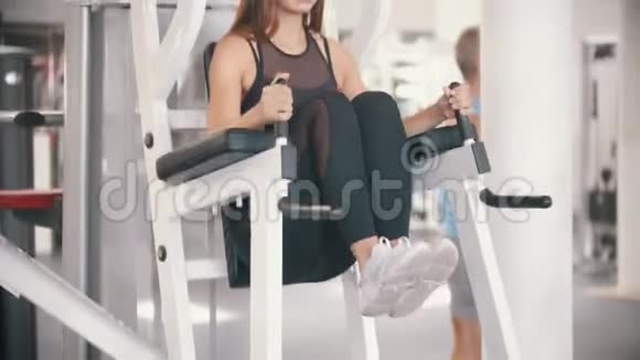一位在健身房锻炼的女运动员靠在手臂上把腿拉到自己身上视频的预览图