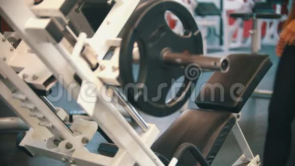 一位在健身房训练的女运动员坐在训练器械上视频的预览图