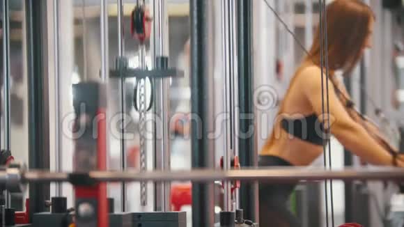 一名运动员女子在健身房训练用上街区的牵引力训练她的手视频的预览图