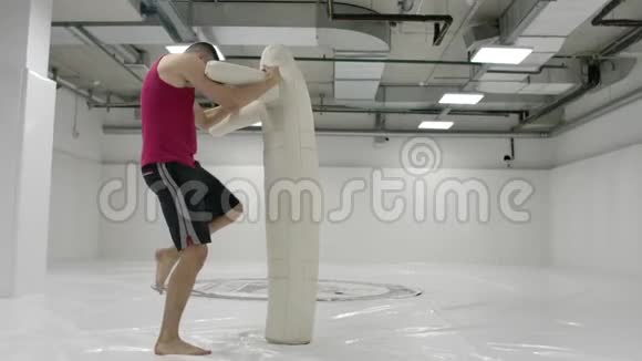 一个拳击手在健身房中缓慢地进行膝盖踢和假人投掷视频的预览图