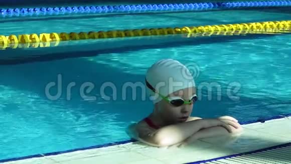 少女面对游泳池靠近在度假池水中微笑的女人肖像视频的预览图