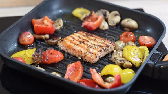 在烤架上可以看到美味的鲑鱼和蔬菜烤制方形三文鱼红辣椒和黄椒樱桃视频的预览图