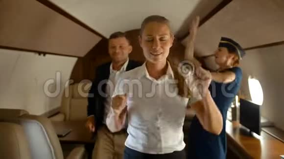 富有的商务同事和空中小姐在飞机头等舱内跳舞视频的预览图