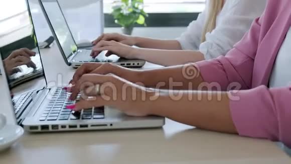 两个聪明的年轻女商人在同事的地方用笔记本电脑工作视频的预览图