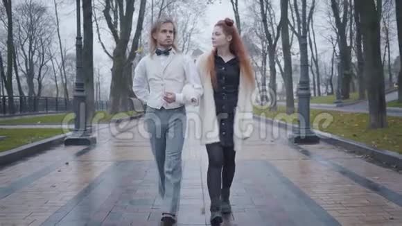 白种人年轻夫妇在秋天公园散步和交谈的肖像快乐的男朋友和女友在户外约会视频的预览图