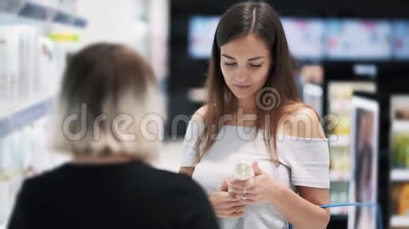 买货女孩在化妆品店跟店员说话慢动作视频的预览图