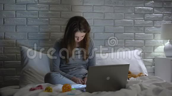 精疲力竭的年轻母亲在笔记本电脑前睡着了缺乏闲暇时间视频的预览图