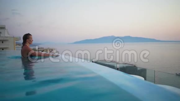 豪华暑假在旅游度假酒店的无限游泳池里穿着比基尼在水下游泳的女人优雅的女士视频的预览图
