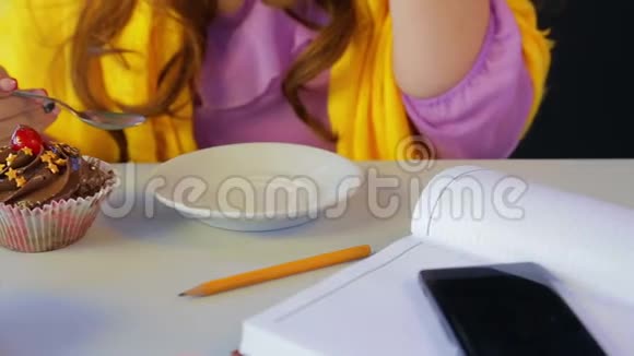 桌旁咖啡馆的女孩喝绿茶用勺子吃蛋糕视频的预览图