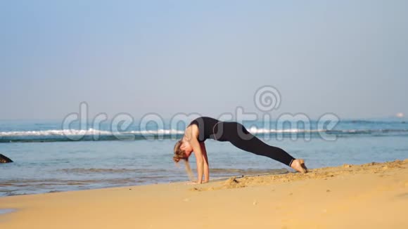 穿黑色运动服的金发女孩练瑜伽姿势眼镜蛇视频的预览图