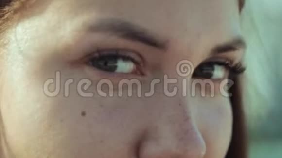 一个长着漂亮眼睛的黑发女人的雀斑脸眨得极其缓慢有魅力的年轻女性视频的预览图