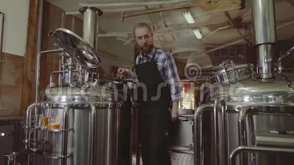 家庭商业概念男女在小型啤酒厂从事酿造机的工作视频的预览图